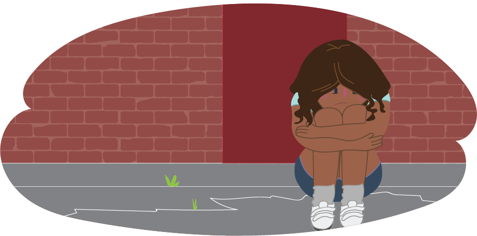 Girl with her head in her knees against a brick wall